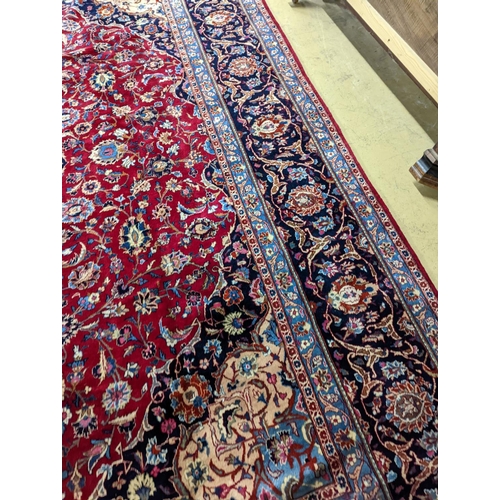 99 - A Kashan burgundy ground carpet, 380 x 300cm