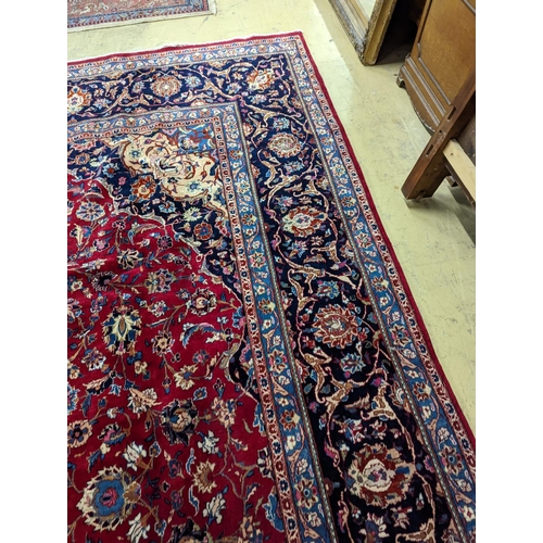 99 - A Kashan burgundy ground carpet, 380 x 300cm