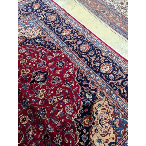 99 - A Kashan burgundy ground carpet, 380 x 300cm