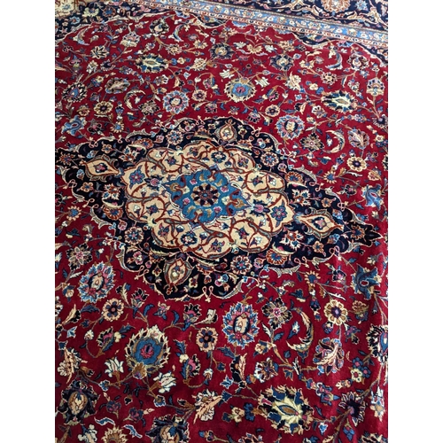 99 - A Kashan burgundy ground carpet, 380 x 300cm