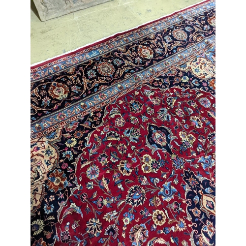 99 - A Kashan burgundy ground carpet, 380 x 300cm