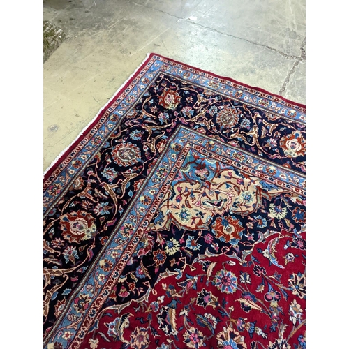 99 - A Kashan burgundy ground carpet, 380 x 300cm