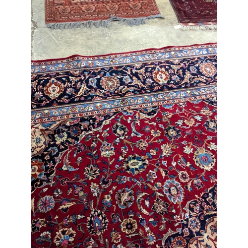 99 - A Kashan burgundy ground carpet, 380 x 300cm