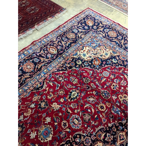 99 - A Kashan burgundy ground carpet, 380 x 300cm