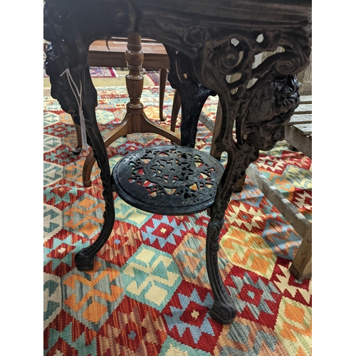 112 - A Victorian cast iron Britannia table with circular weathered wood top, diameter 58cm, height 69cm... 