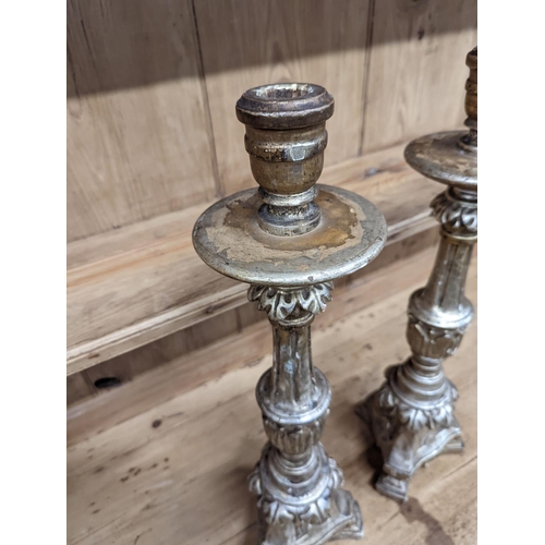 130 - A pair of 18th century style carved silvered wood candlesticks, height 58cm