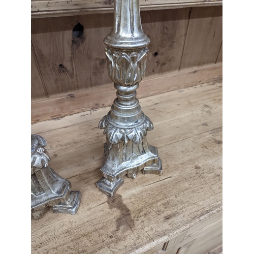 130 - A pair of 18th century style carved silvered wood candlesticks, height 58cm