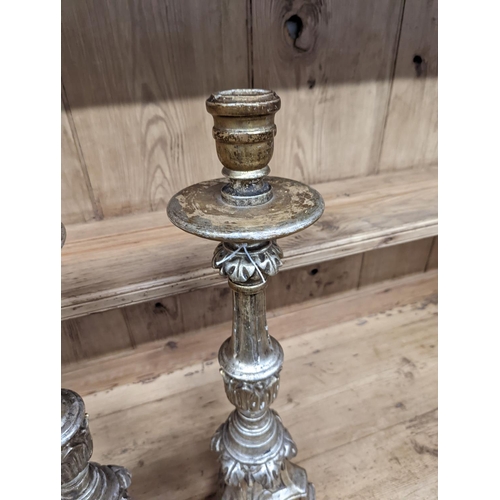 130 - A pair of 18th century style carved silvered wood candlesticks, height 58cm