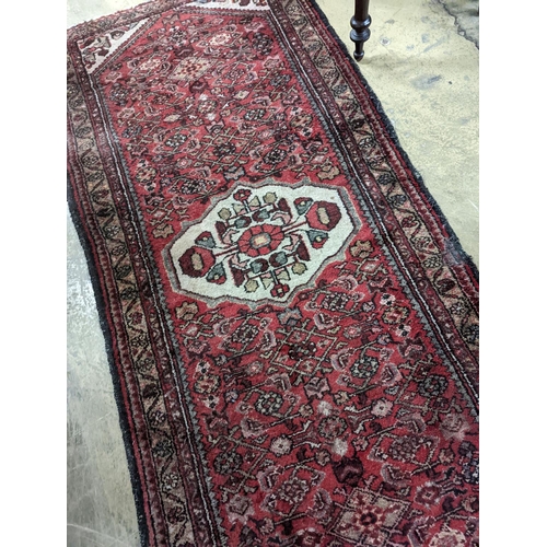 169 - A Hamadan red ground rug, 190 x 82cm