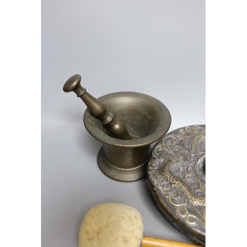 422 - Two pestles and mortars and a Chinese gong with beater, gong 21 cms wide.