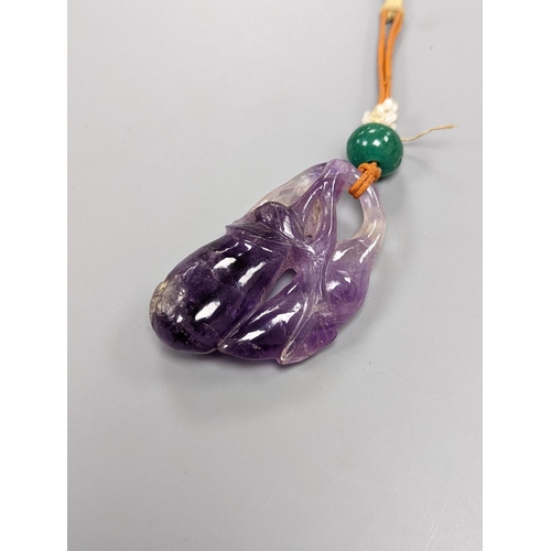 519 - A 19th century Chinese carved amethyst pendant, 5cm., on ornate cord