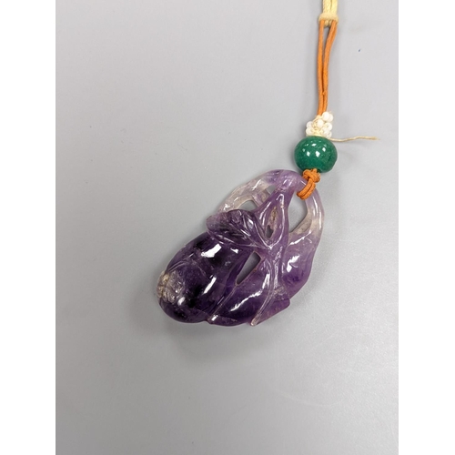 519 - A 19th century Chinese carved amethyst pendant, 5cm., on ornate cord