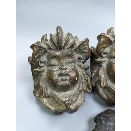 528 - A set of three cast bronze mask-form furniture mounts, 9cm. high,   