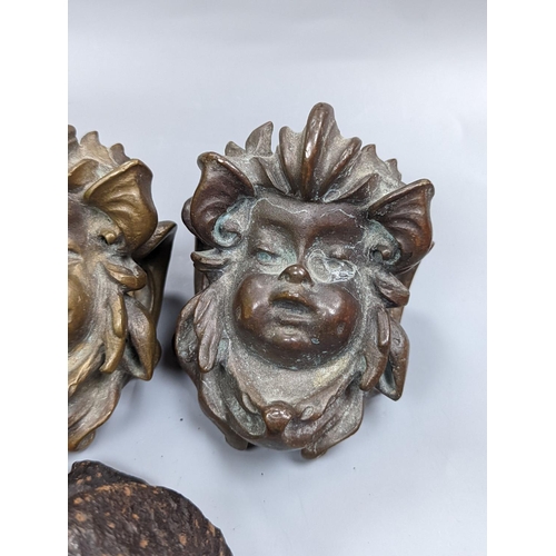 528 - A set of three cast bronze mask-form furniture mounts, 9cm. high,   