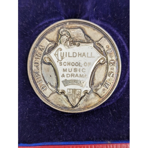 529 - A silver Guildhall School elocution medal, 1935, and a humorous watercolour