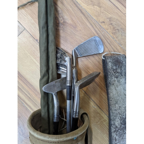 547 - A split cane fishing rod, quantity of golf clubs, cows bell