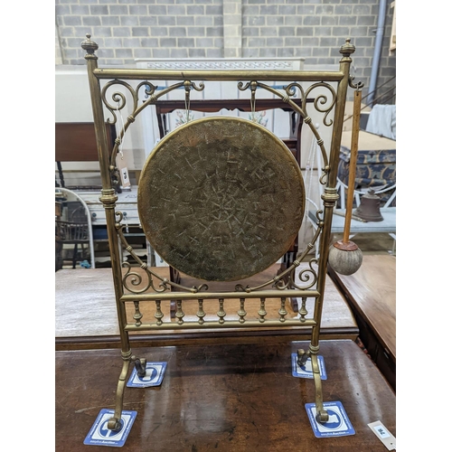 75 - An Edwardian brass dinner gong with striker, width 50cm, height 84cm