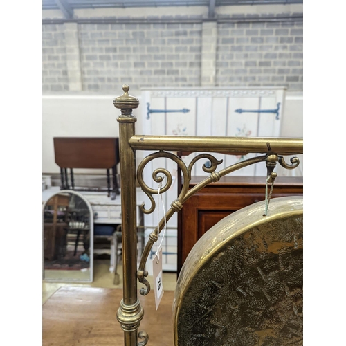 75 - An Edwardian brass dinner gong with striker, width 50cm, height 84cm