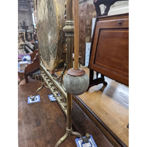 75 - An Edwardian brass dinner gong with striker, width 50cm, height 84cm