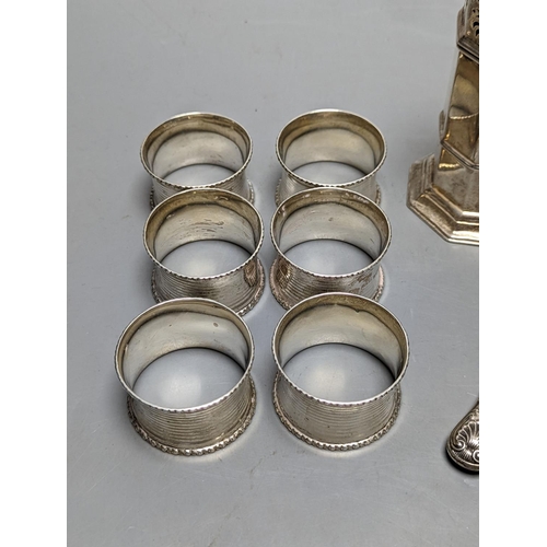 844 - A set of six George V silver napkin rings, Birmingham, 1915, a silver sugar caster and silver butter... 