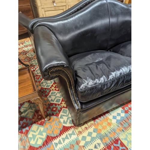 88 - A pair of black leather scroll arm two seater settees on flat bun feet, length 184cm, depth 80cm, he... 