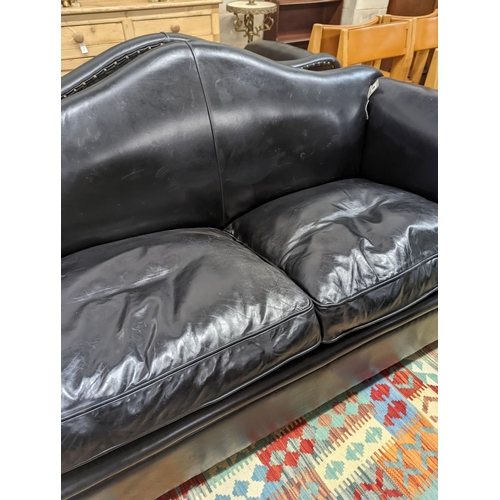 88 - A pair of black leather scroll arm two seater settees on flat bun feet, length 184cm, depth 80cm, he... 