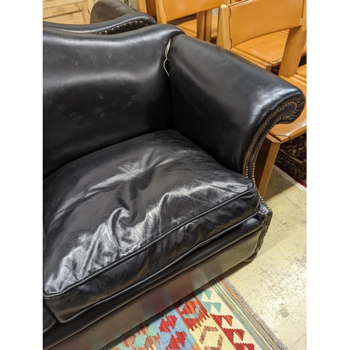 88 - A pair of black leather scroll arm two seater settees on flat bun feet, length 184cm, depth 80cm, he... 