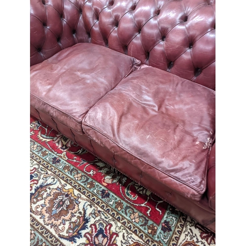 92 - A Victorian style buttoned burgundy leather Chesterfield settee, length 172cm, depth 90cm, height 73... 