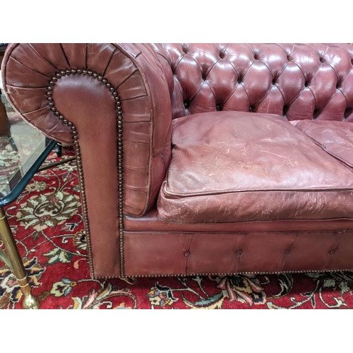 92 - A Victorian style buttoned burgundy leather Chesterfield settee, length 172cm, depth 90cm, height 73... 