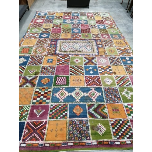 18 - A Caucasian style wool carpet, woven with polychrome geometric squares, 430 x 260cm