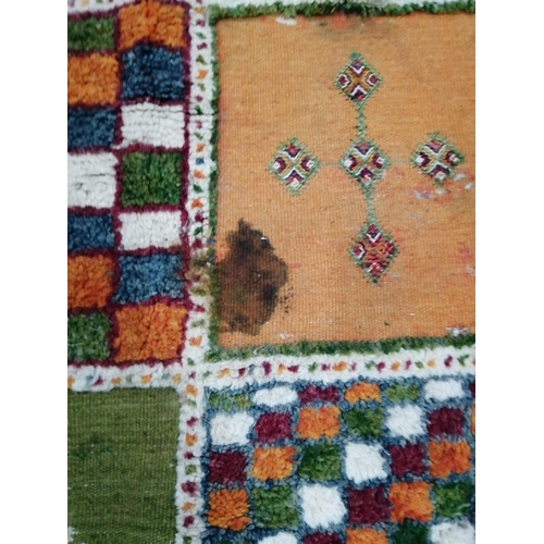 18 - A Caucasian style wool carpet, woven with polychrome geometric squares, 430 x 260cm