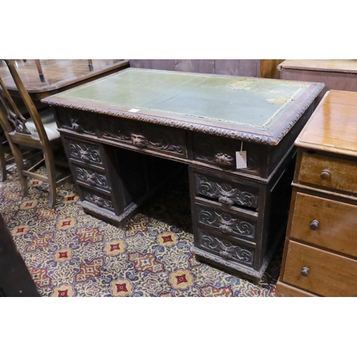 30 - A late Victorian carved oak pedestal desk, length 121cm, depth 70cm, height 75cm