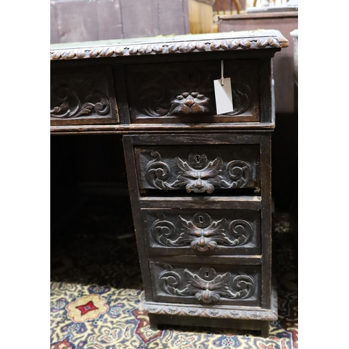 30 - A late Victorian carved oak pedestal desk, length 121cm, depth 70cm, height 75cm