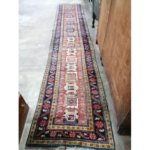 37 - A Caucasian design brick red ground runner, 430 x 80cm