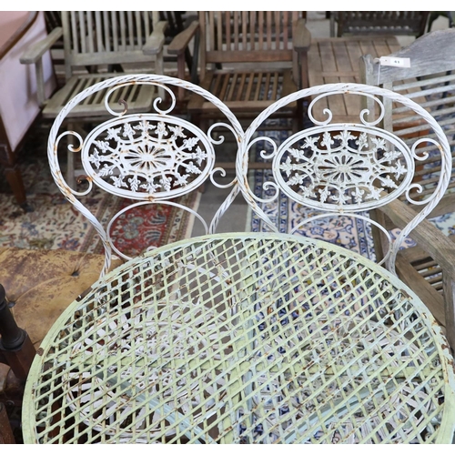 40 - A wrought iron circular garden table, diameter 65cm, height 74cm and four folding chairs... 
