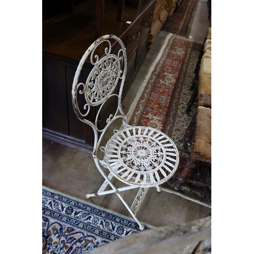 40 - A wrought iron circular garden table, diameter 65cm, height 74cm and four folding chairs... 