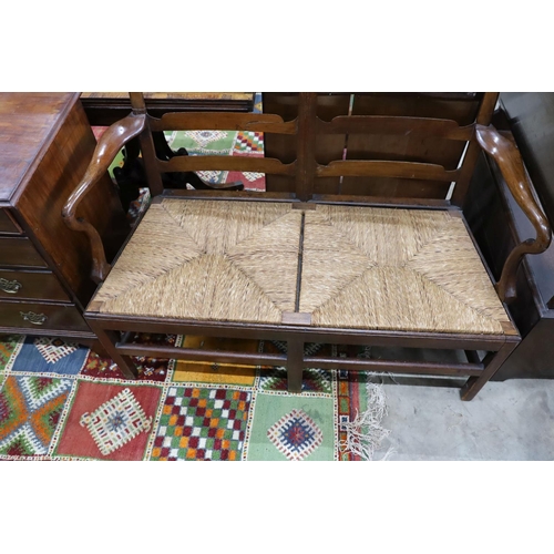 58 - A George III provincial mahogany rush seat chair back settee, length 118cm, depth 53cm, height 100cm... 