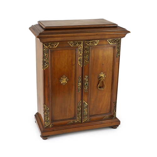 1422 - A late 19th century gilt metal mounted walnut games cabinet,with two panelled doors enclosing slidin... 