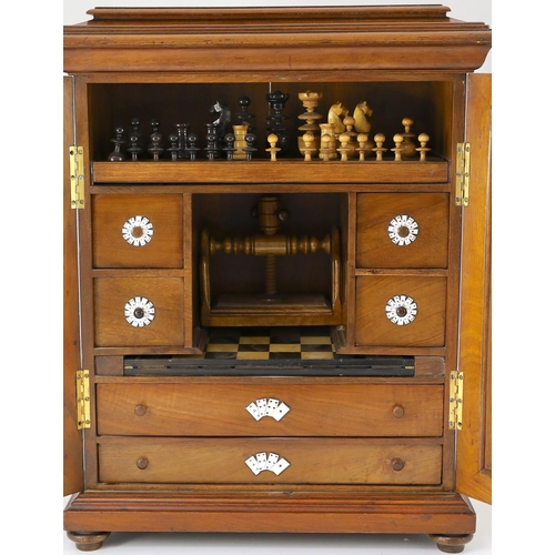 1422 - A late 19th century gilt metal mounted walnut games cabinet,with two panelled doors enclosing slidin... 