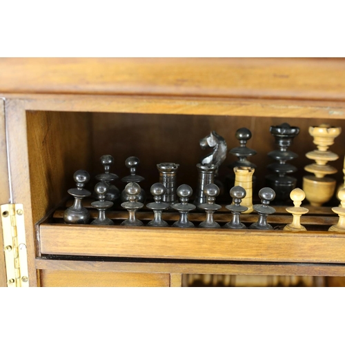 1422 - A late 19th century gilt metal mounted walnut games cabinet,with two panelled doors enclosing slidin... 