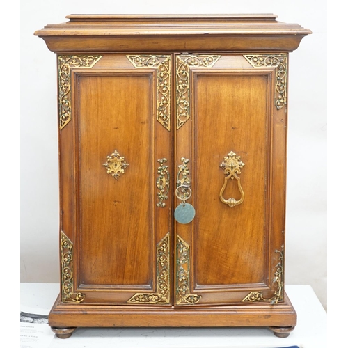 1422 - A late 19th century gilt metal mounted walnut games cabinet,with two panelled doors enclosing slidin... 