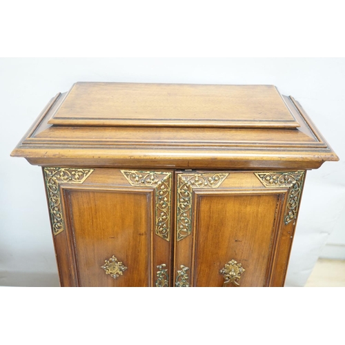 1422 - A late 19th century gilt metal mounted walnut games cabinet,with two panelled doors enclosing slidin... 