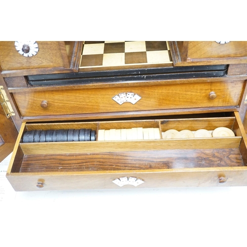 1422 - A late 19th century gilt metal mounted walnut games cabinet,with two panelled doors enclosing slidin... 