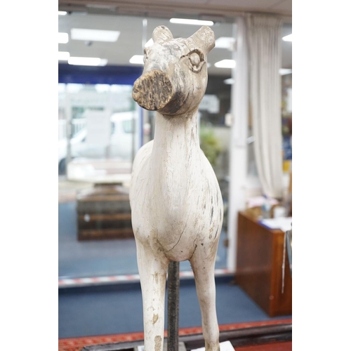 1590 - A carved and painted wood model of a goat, with distressed paint, on stand. 66cm