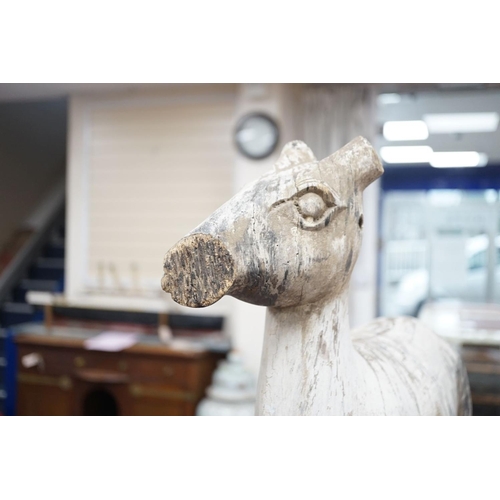 1590 - A carved and painted wood model of a goat, with distressed paint, on stand. 66cm