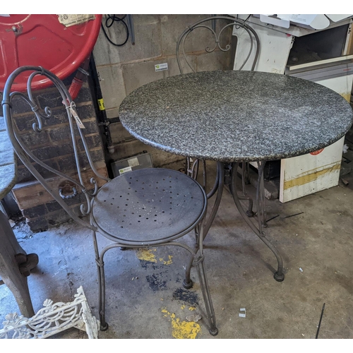 1004 - A circular stone top garden table, diameter 75cm, height 72cm and two chairs