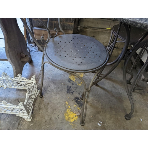 1004 - A circular stone top garden table, diameter 75cm, height 72cm and two chairs