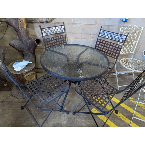 1006 - A circular glass top garden table, diameter 80cm, height 71cm and four metal folding garden chairs... 