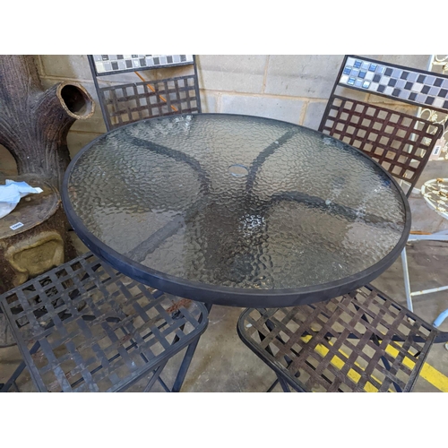 1006 - A circular glass top garden table, diameter 80cm, height 71cm and four metal folding garden chairs... 