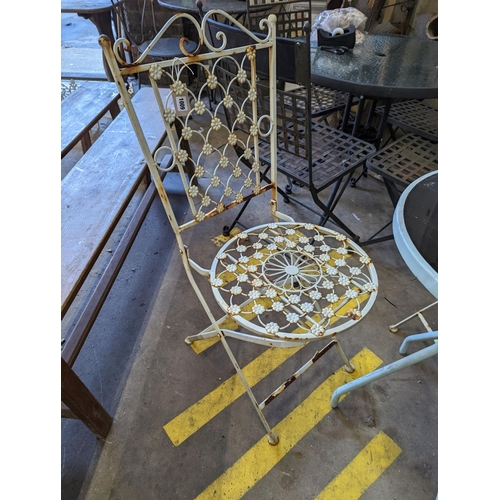 1009 - A circular glass top bistro table, diameter 50cm, height 72cm together with two painted metal chairs... 